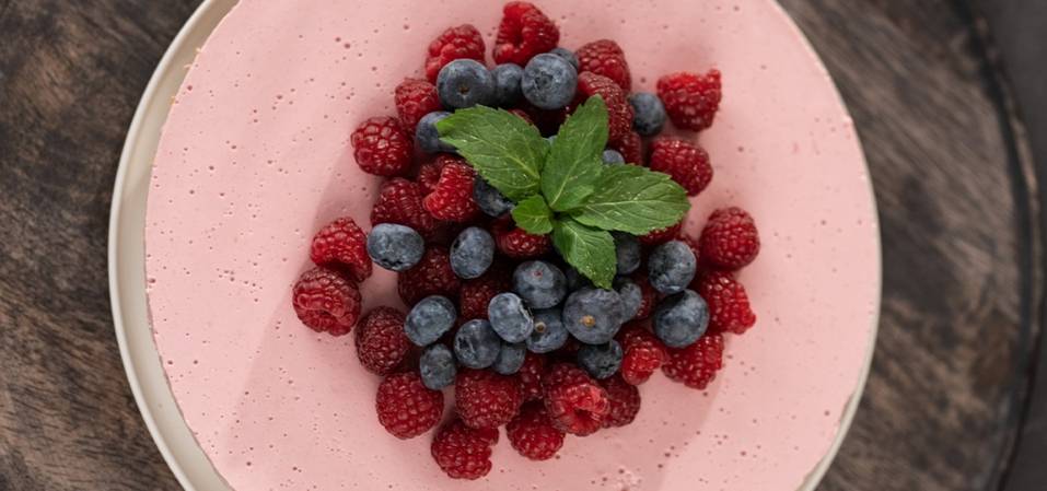 Rosa Kuchen mit Himbeeren und Blaubeeren.
