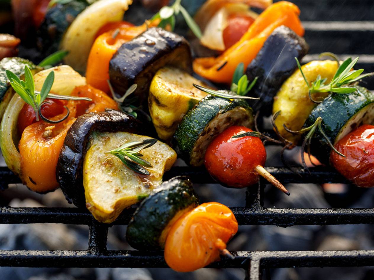 Gemüse-Spieße mit Zucchini, Aubergine, Paprika und Tomaten auf einem Grillrost.
