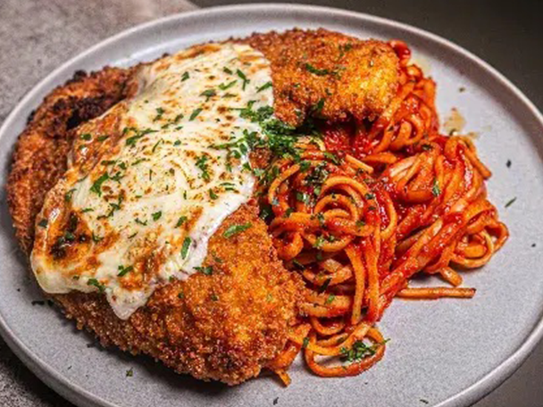Hähnchen Parmesan mit Spaghetti in Tomatensauce auf einem Teller