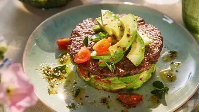 Burger mit Avocado und Kirschtomaten.