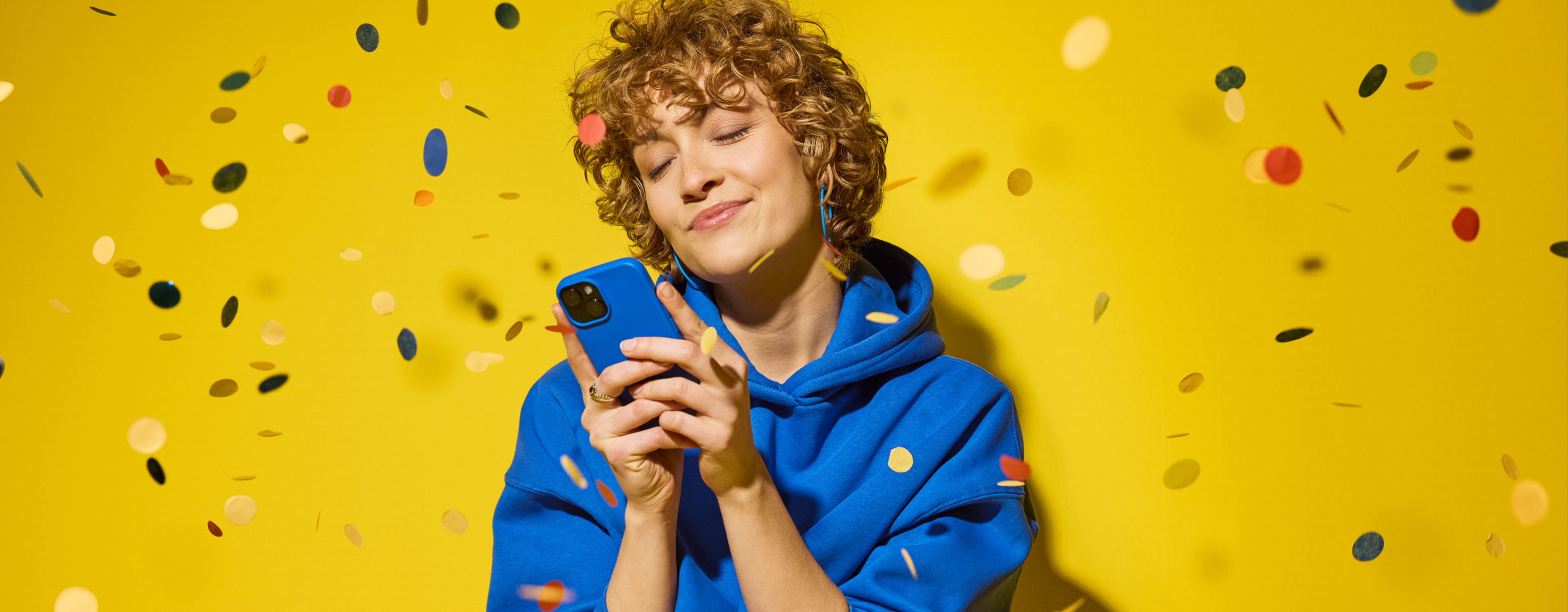 Person hält Handy in der Hand und freut sich über einen Gewinn nach einem Einkauf mit Lidl Plus.