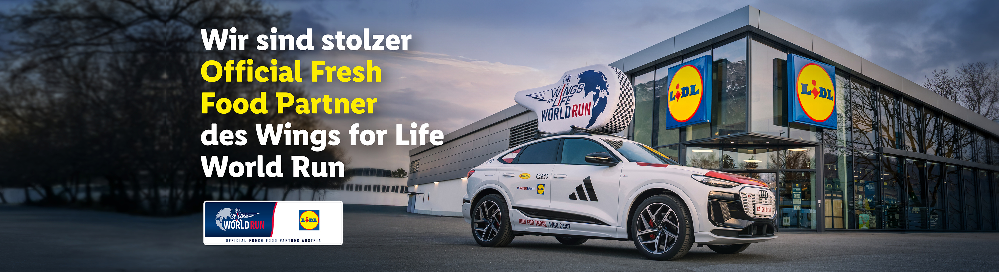 Ein weißes Auto mit einem Dachaufsatz für einen Wohltätigkeitslauf steht vor einem Supermarkt.