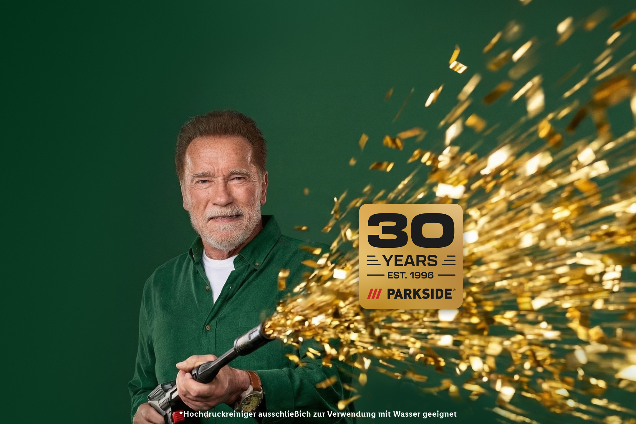 Mann mit Bart hält einen Hochdruckreiniger, umgeben von goldenem Konfetti, mit einem 30-Jahre-Jubiläumslogo.
